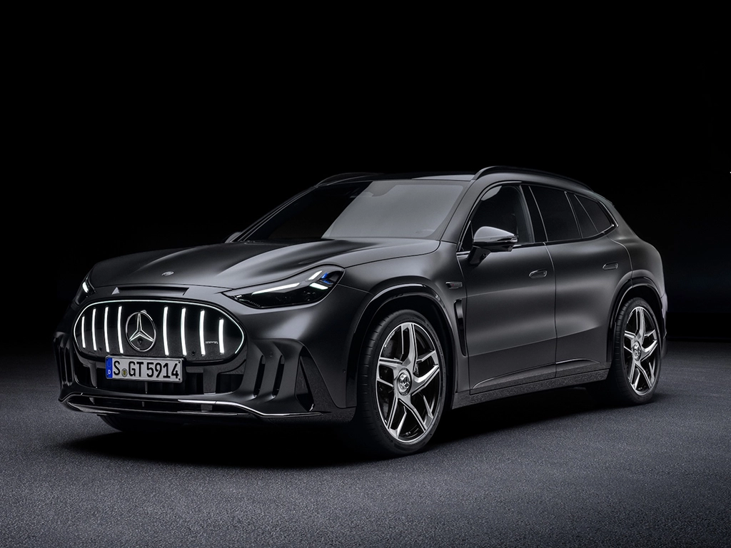 A dark grey Mercedes-AMG GT SUV photographed in a black studio, three-quarter front view
